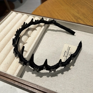 Detail of black velvet headband with punk spikes and rhinestone butterfly ornament