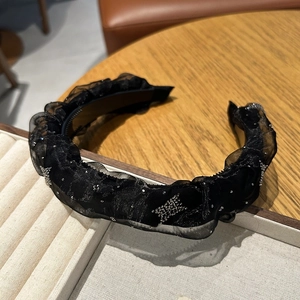 Détail d'un serre-tête en tulle plissé noir avec étoiles en strass et dents antidérapantes