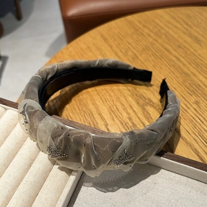 Détail du serre-tête en tulle gris avec étoiles en strass et design antidérapant