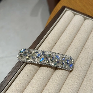 Macro shot of silver hair clip with colorful AB crystals and sparkling rhinestone floral pattern