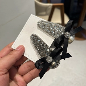 Close-up of sparkling bow hair clips with rhinestones and faux pearl embellishments