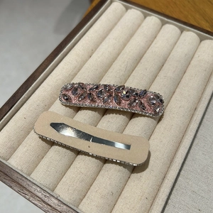 Detailed view of silver metal spring clips and protective pads on heart-shaped hairpins