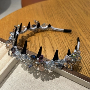 Detail eines Kristall-Haarreifs mit schwarzen Punk-Spikes und facettierten Glasperlen