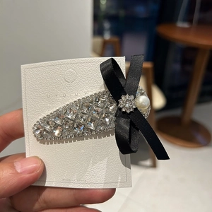 Elegant rhinestone bow hair clip with luxury crystals and faux pearl on white card