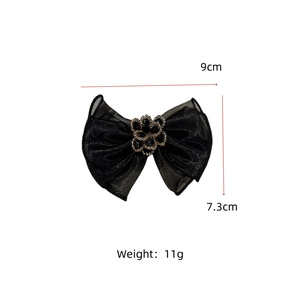 Detail view of 9cm black mesh bow hair clip with sparkling rhinestone flower and metal trim