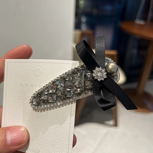 Elegant rhinestone bow hairpin with grey crystals and pearl on white display card
