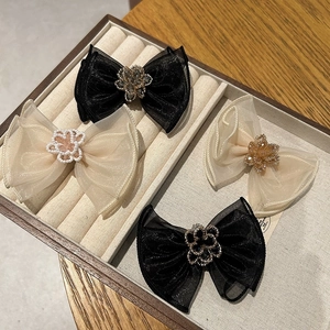 Close-up of elegant mesh bow hair clips with crystal flower centerpieces in a jewelry tray