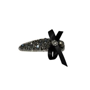 Elegant bow hair clip with gray crystals and pearls on a white background