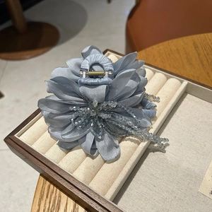 Detailed shot of silk blue flower hair claw with crystal beads and elegant long tassels