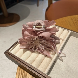 Detail view of pink fabric flower hair claw clip with delicate beaded tassel fringe