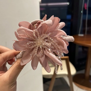 Detailed macro view of a pink satin floral hair claw clip with crystal bead stamen detail