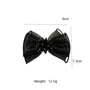 Détail d'une pince à cheveux de 9cm en organza noir avec nœud en perles et strass élégants