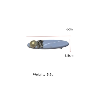 Detail view of a 6cm light blue hair clip with pearl and rhinestone bear design