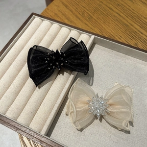 Détail de pinces à cheveux en organza multicouche avec centre floral en cristal brillant