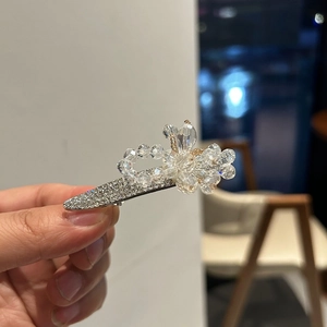 Gros plan détaillé d'une pince à cheveux fleur en cristal argenté avec strass brillants