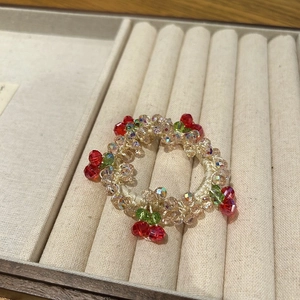 Detail of high-elastic beaded hair tie with red crystal cherry charm in jewelry box