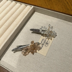 Vue détaillée des pinces à cheveux fleur en cristal avec finition métal argenté et strass
