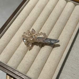 Vue détaillée de la barrette fleurie en cristal champagne avec strass dans un coffret