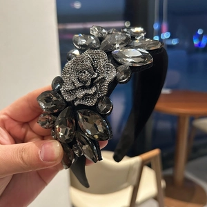 Close-up of luxury black padded headband with gray crystals and rhinestone rose detail