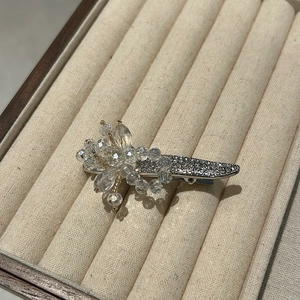 Vue détaillée de la pince à cheveux fleur en cristal argenté avec des strass brillants