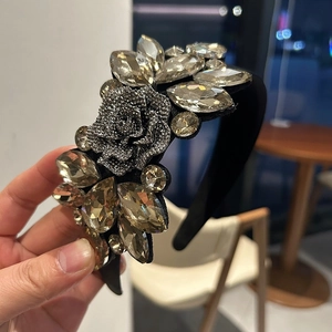 Detailed macro of crystal-embellished wide headband with silver rose and champagne stones