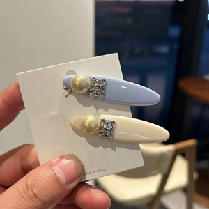 Detail of blue and cream capsule hair clips with pearl and rhinestone bear charms