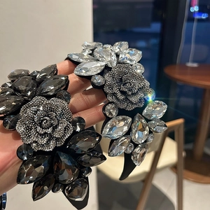 Close-up of handmade luxury rhinestone rose headbands in silver and charcoal gray