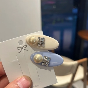 Detail of two-piece hair clips set with faux pearls and sparkling rhinestone bears