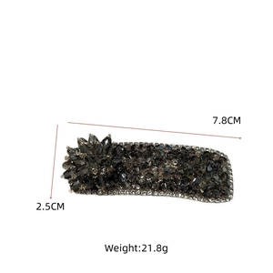 Macro detail of dark grey crystal hair clip with floral accents and 7.8cm metal base
