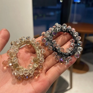 Detailed close-up of handmade crystal beaded hair ties with faceted amber and clear beads