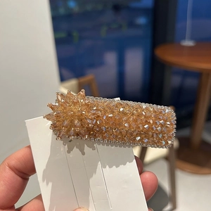 Handheld amber beaded square hair clip with floral accents and sparkling rhinestones