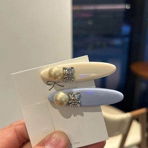 Detail of mini duckbill hair clips with faux pearl and rhinestone bear decorations