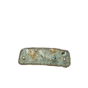 Ocean style shell hair clip with pearls and rhinestones on light green base