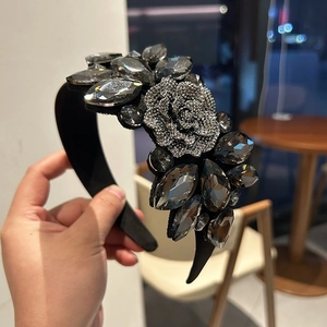 Detail of a black baroque headband featuring handmade crystals and a rhinestone rose