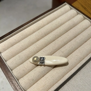 Detail view of a cream acetate hair clip with a sparkling bear and cat eye stone