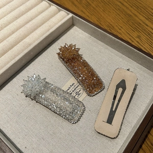 Detailed view of luxury crystal hair clips in champagne gold and white with metal alloy base