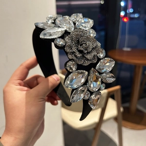 Detail of luxury velvet headband featuring large rhinestones and a grey crystal flower