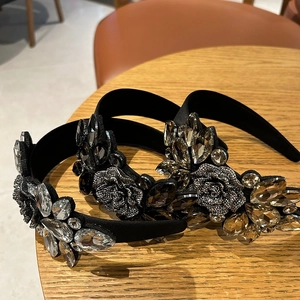 Detailed close-up of crystal flower headbands with champagne and silver rhinestones on velvet