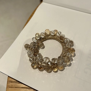 Close-up of elegant crystal beaded hair tie with champagne and clear faceted beads