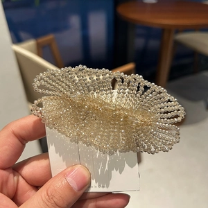 Detail of handcrafted champagne crystal beads on a woven hair clip showing fine luster