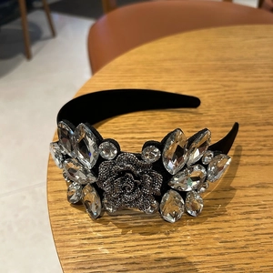 Close-up of velvet headband featuring intricate crystal droplets and 3D floral gemstone detail