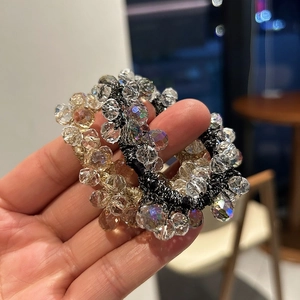 Detail of beaded hair ties with amber and iridescent crystals on metallic wire