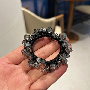 Dettaglio di un elastico nero per capelli ad alta elasticità con perle di cristallo