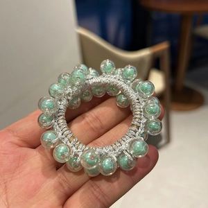 Detailed view of hand-woven silver hair tie with mint green jelly beads in high resolution