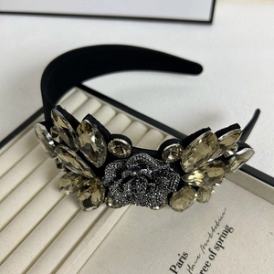 Macro detail of luxury black headband featuring champagne crystals and silver flower inlay
