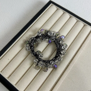 Detail of premium crystal beaded hair tie with iridescent faceted beads on velvet display