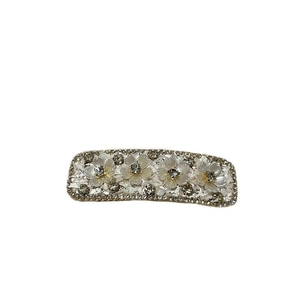 Elegant gold metal floral hair clip with white stones and sparkling rhinestones