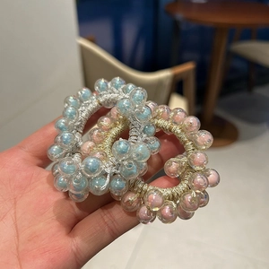 Close-up of iridescent jelly beaded hair ties in shimmering blue and pink colors
