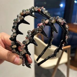 Dettaglio di un cerchietto fatto a mano con perline di cristallo colorate e denti di presa
