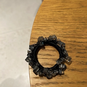 Dettaglio dell'elastico per capelli nero con perle di cristallo grigio fumo sfaccettate